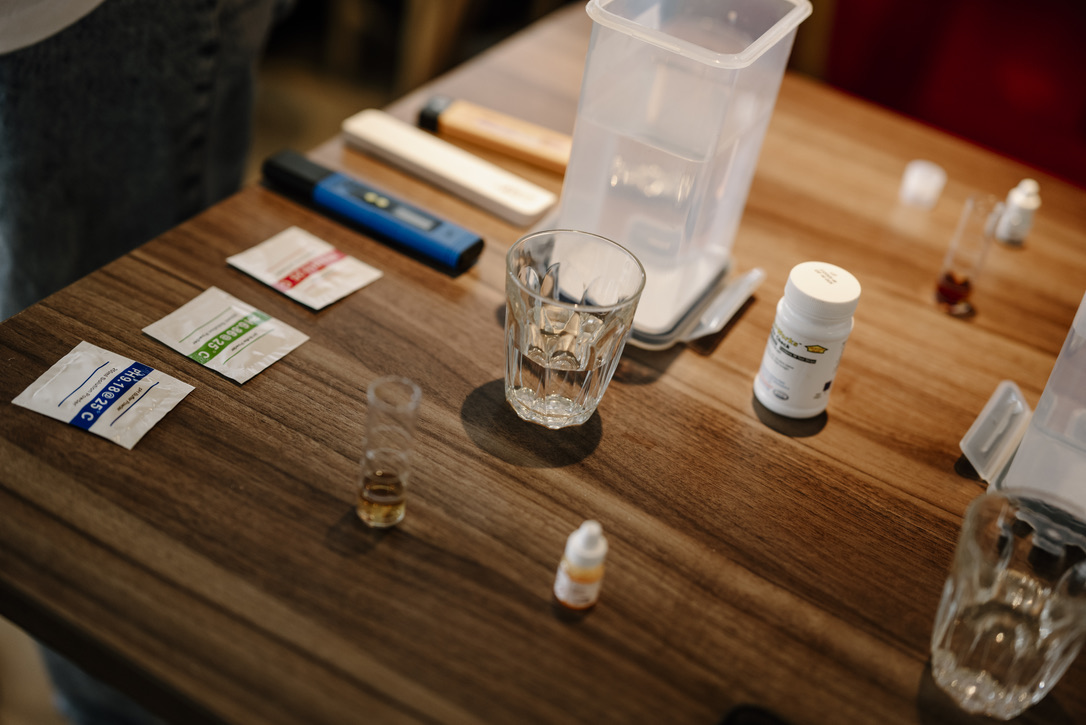 Water testing kit on a table: TDS and pH meters, calibration sachets, reagents and sample glasses